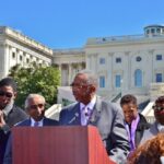 Bobby Rush at podium, falnked by Charlie Rangel, immediate left, Evet Clarke, far right